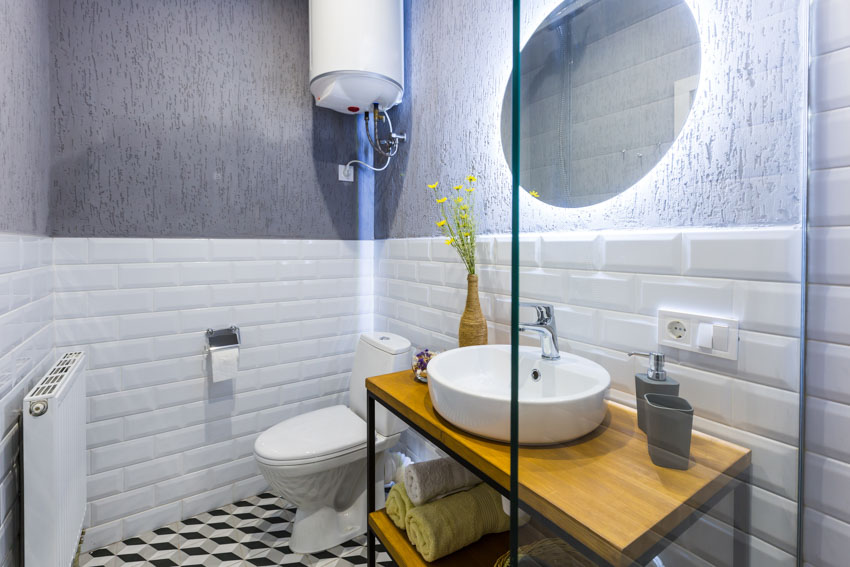 Bathroom with vanity area, mirror, wood countertop, sink, faucet, toilet, and waterproof peel and stick floor tiles