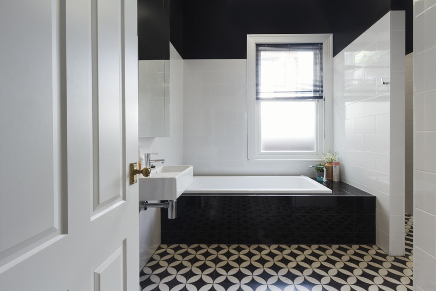 Bathroom with waterproof peel and stick floor tiles, tub, door, and window