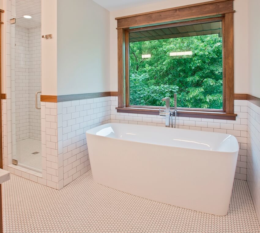 Gorgeous bathroom with penny tile flooring, a free standing bathtub and a separate shower