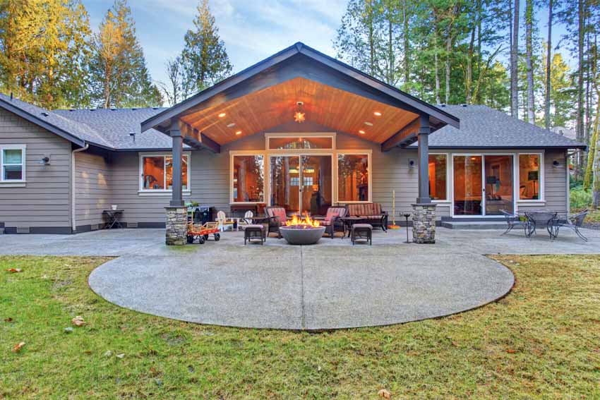 Beautiful house with patio, fire pit, outdoor furniture, patio cover, siding, windows, and glass door