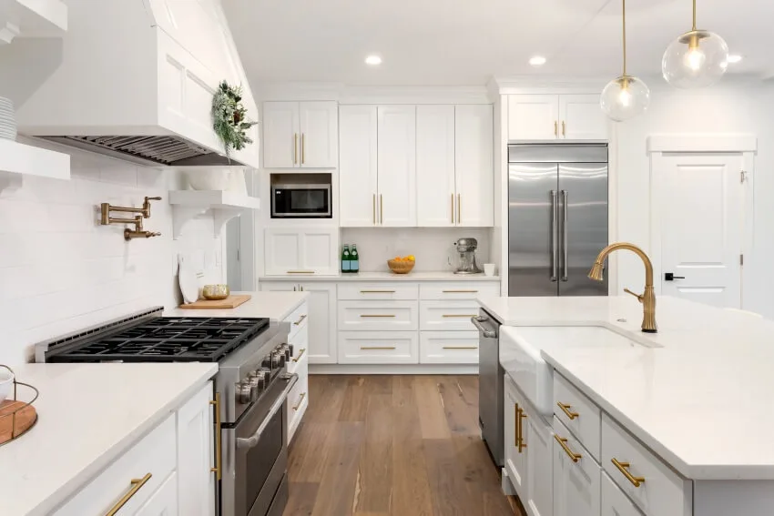 Beautiful kitchen in new luxury home with island shaker style cabinet doors and hardwood floors