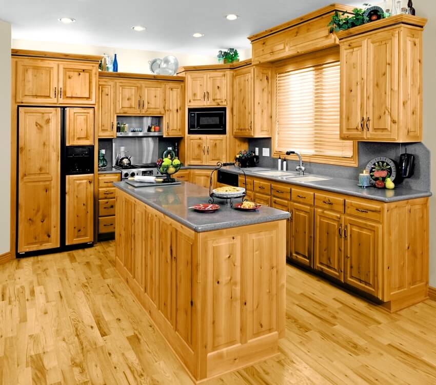 A beautiful kitchen with knotty pine kitchen cabinets and grey countertops
