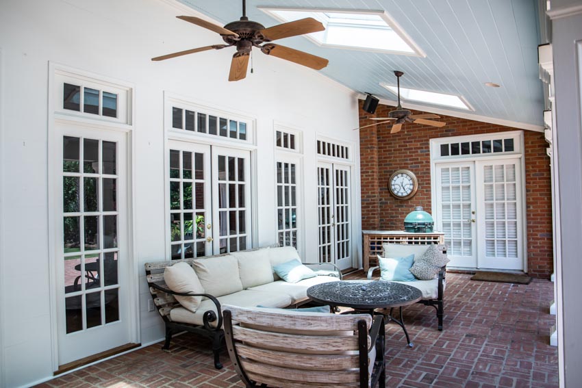 Beautiful patio area with couch, chairs, coffee table, ceiling fan, and french patio doors