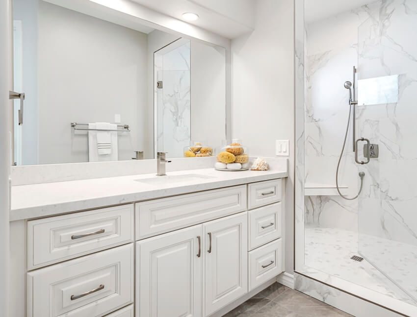 A beautiful white modern bathroom design with laminate countertops and marble shower