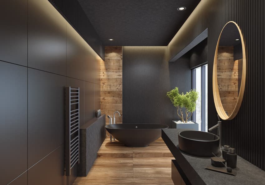 Black bathroom with countertop, mirror, tub, window, and wood floor