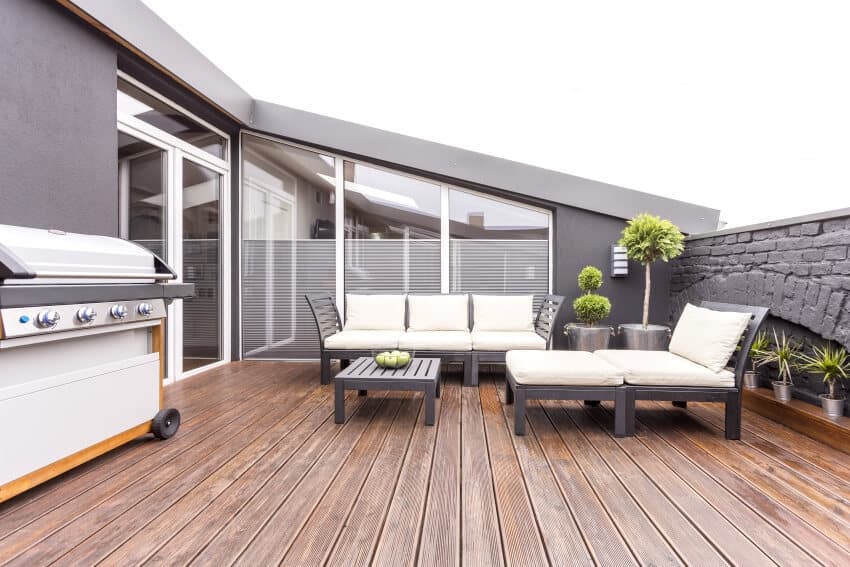Patio with outdoor furniture, grill, sliding door and grey walls