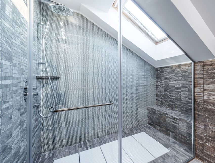 Bright shower with penny tile walls and window