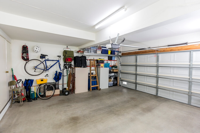 Clean suburban two car garage interior with tools, file cabinets, and sports equipment