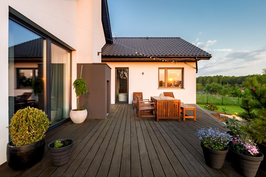 Cozy villa patio with decorative plants and dark matte paint wood flooring