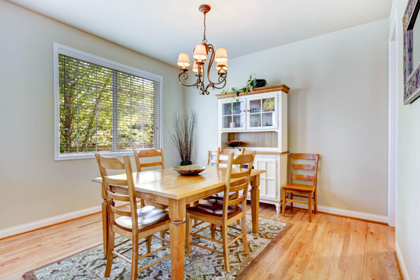 Dining room with floor rug, wood table, chairs, cabinet, and horizontal window blinds