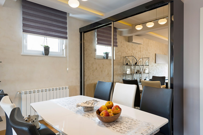 Dining room with mirror, table, chairs, and window blinds