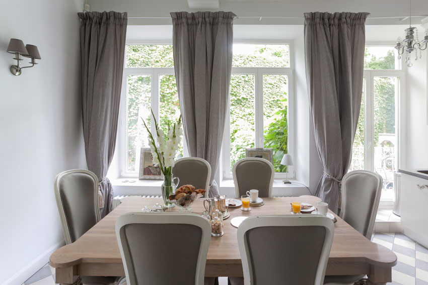 Dining room with table, chairs, and window curtains