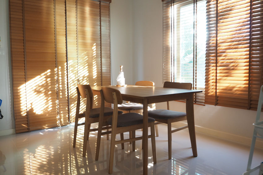 Dining room with textured wood window shutters, table, and chairs