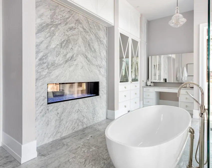 Bathroom with marble wall, fireplace, chandelier and bathtub 