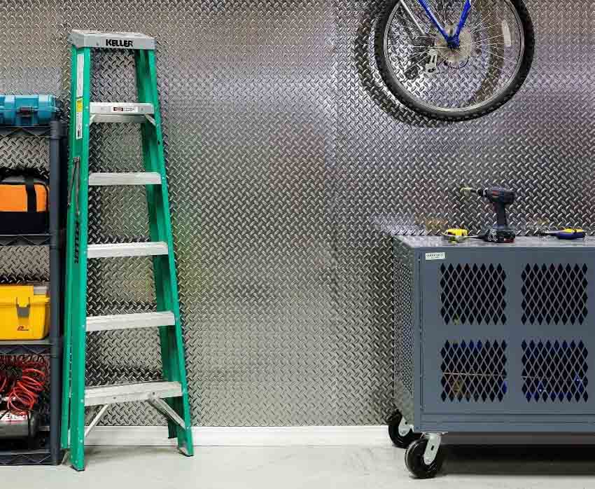 Garage with aluminum diamond plate wall as backsplash, ladder, and tools