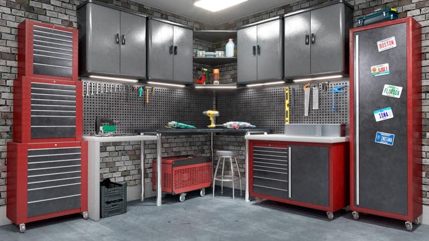 Garage workspace with workbench, backsplash, cabinets, drawers, and concrete flooring