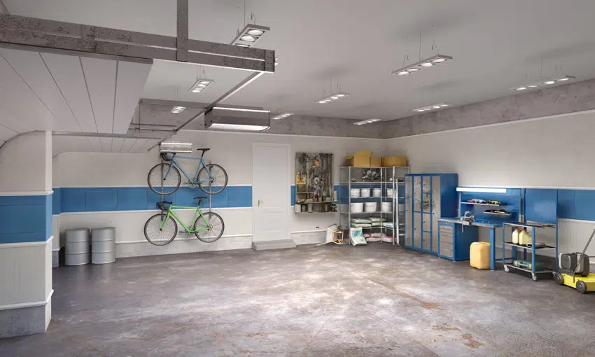 Garage with tile behind workbench, ceiling lights, cabinets, and concrete floor