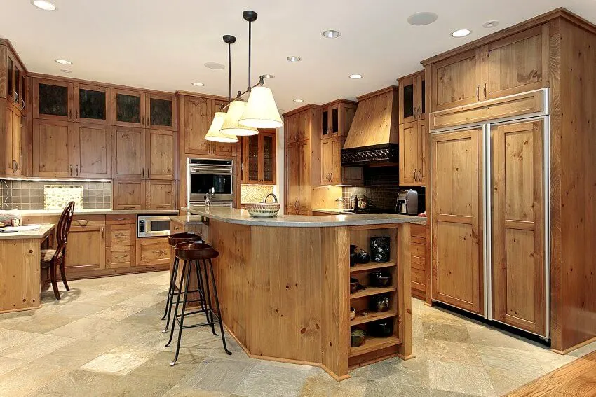 Gorgeous kitchen interior with unfinished knotty pine cabinets, marble floors, and stainless steel appliances