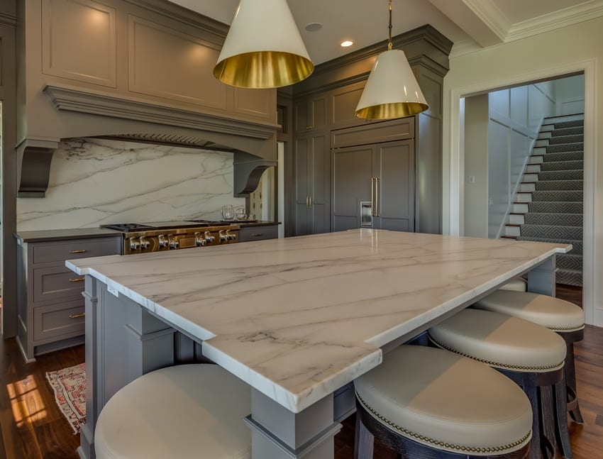 Kitchen with michelangelo marble, gray painted cabinets and brushed gold inside lights