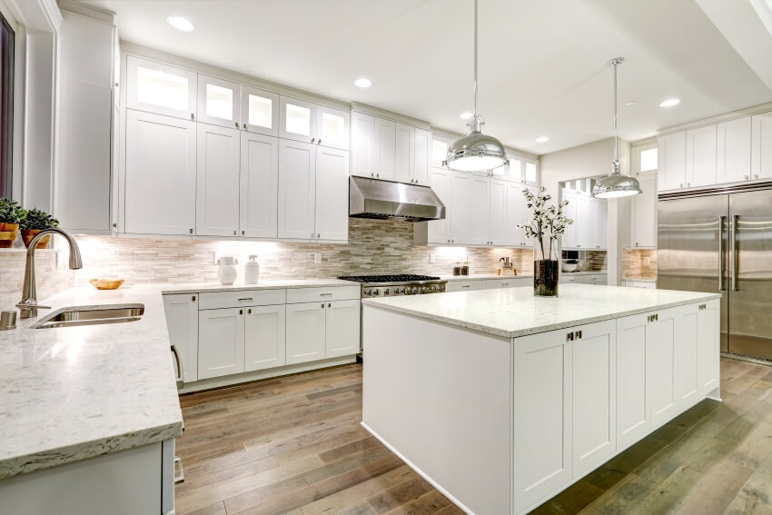 Gourmet kitchen features white shaker cabinets with marble countertops and gorgeous kitchen island