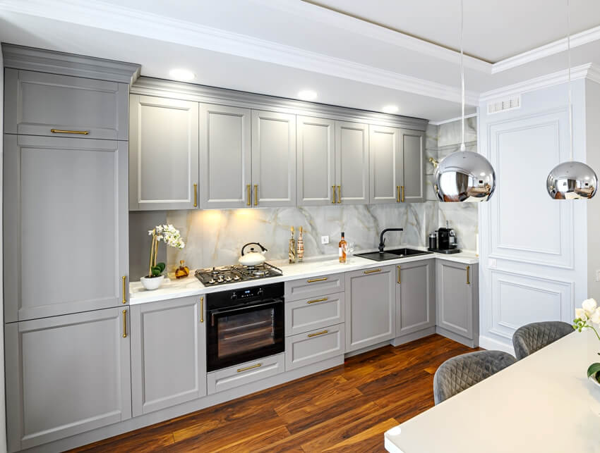 A grey contemporary classic studio kitchen interior with wide and narrow shaker cabinet doors