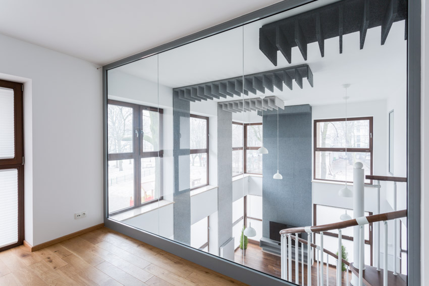 Home interior with big mirror wall panel, and wooden floors