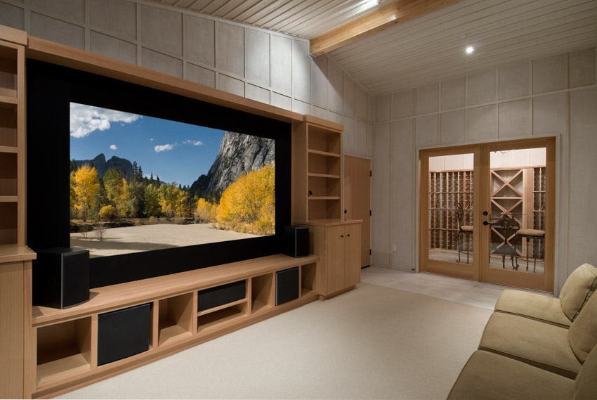 Home theater with entertainment center, beige sofa chairs and wide glass door