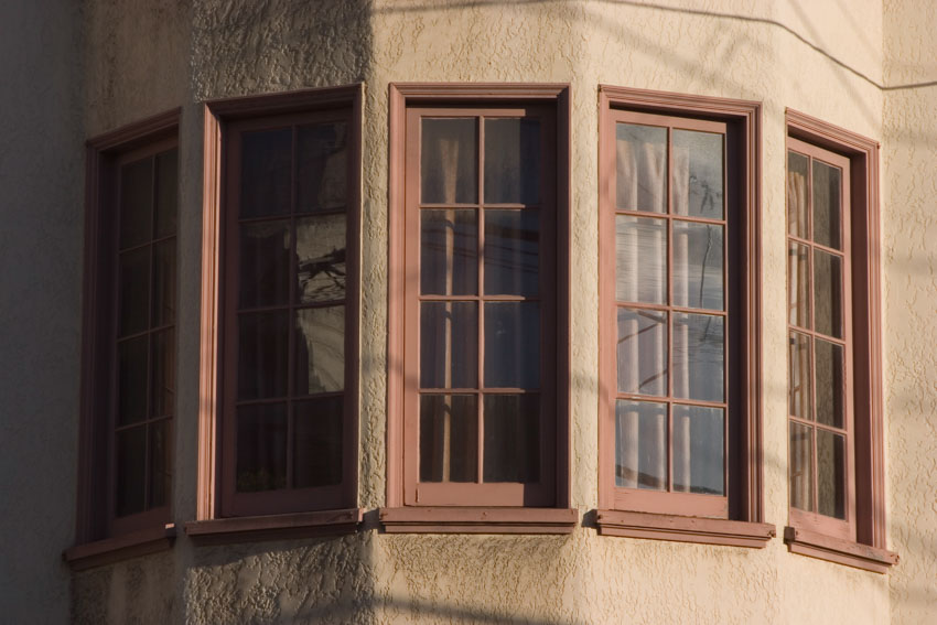 House exterior bow window with wood frames, and glass panels