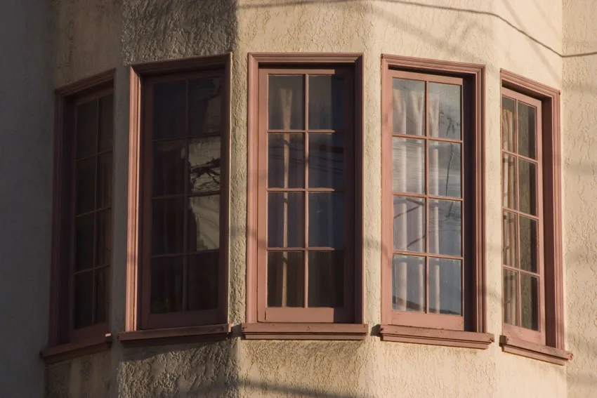 Curved window with wood frames and concrete wall