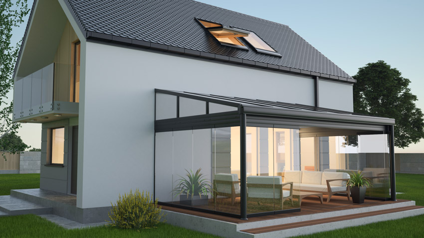 House exterior with patio enclosure, glass door, pitched roof, and skylight window