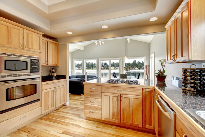 Kitchen with ash cabinets, wood floors, oven, countertop, and windows