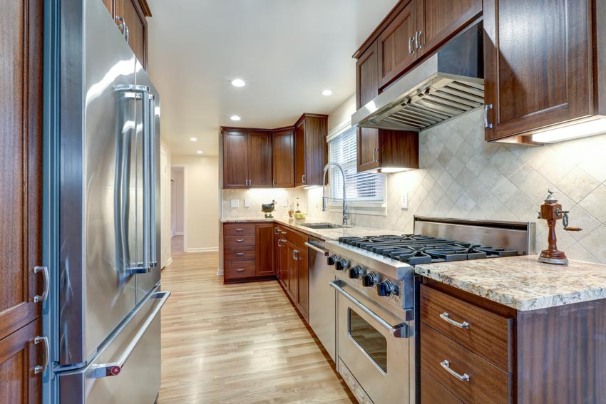 Kitchen with Carrara marble backsplash, countertop, wood floor, dark wood cabinets, and ceiling lights