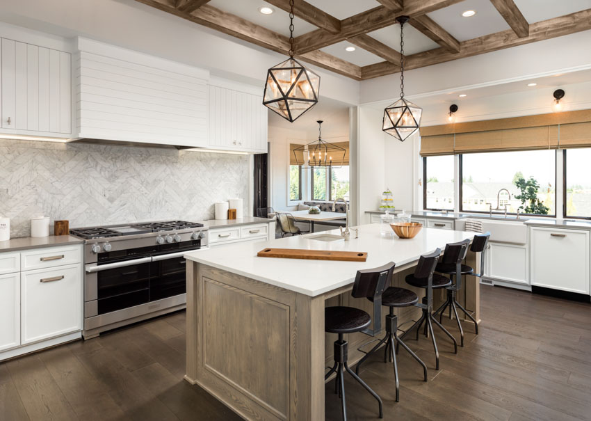 Kitchen with center island, herringbone backsplash, coffered ceiling beams, pendant lights, large oven stove, vinyl flooring and picture windows