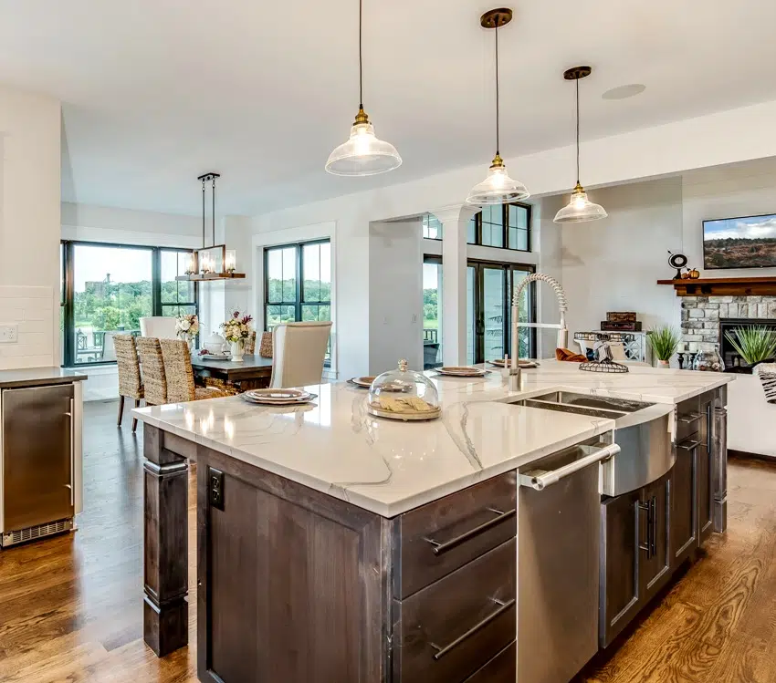 Kitchen with island countertop. steel appliances and stacked stone fireplace