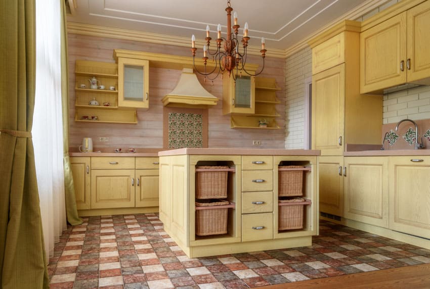 Kitchen with patterned floor, center island, shiplap backsplash, cabinets, chandelier, and range hood