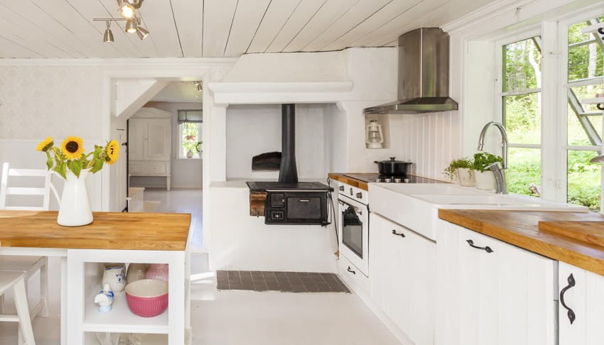 White backsplash behind stove, windows and sink