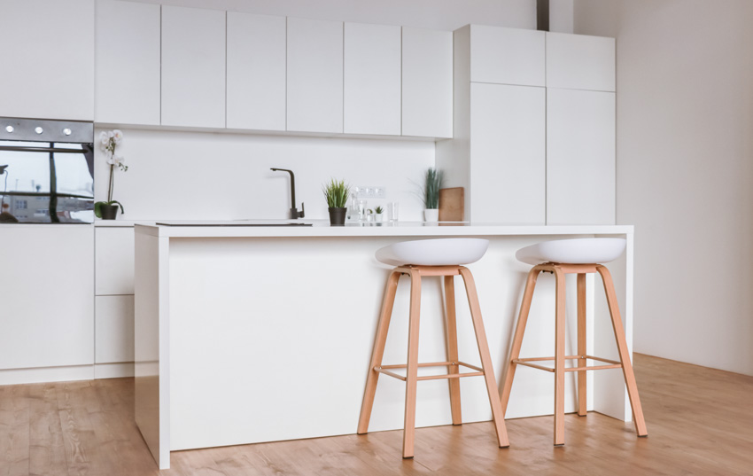 All white minimalist bar with sink and two stools