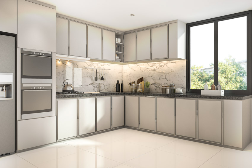 Kitchen with white cabinets, tile flooring, Carrara marble backsplash, and windows