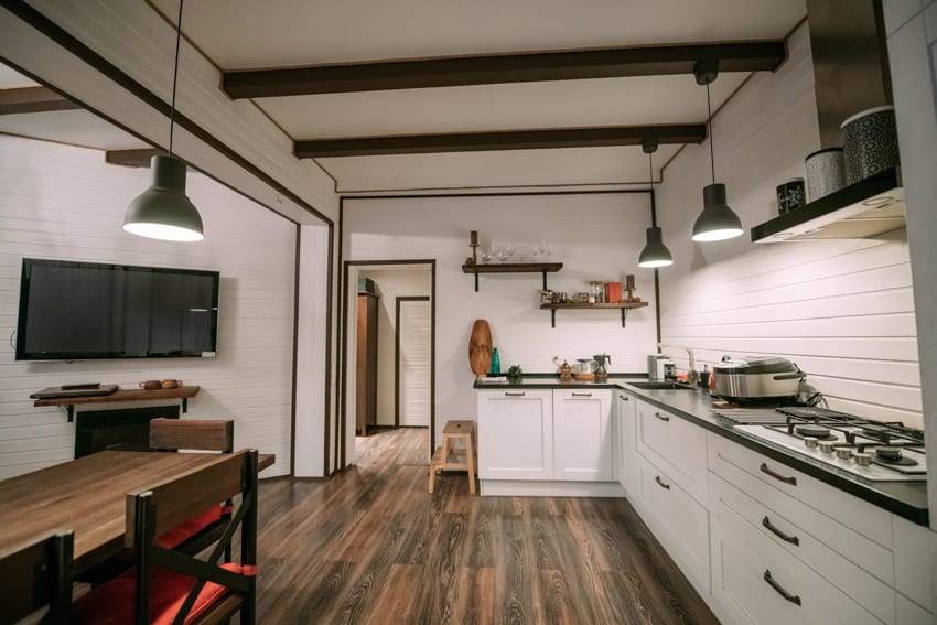 Kitchen with exposed beams and white backsplash