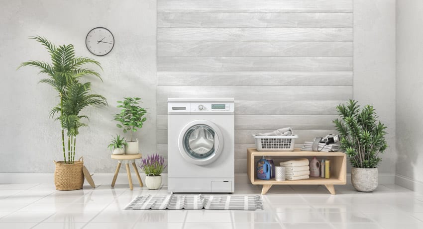 Laundry room with indoor plants, washing machine, and porcelain tile flooring