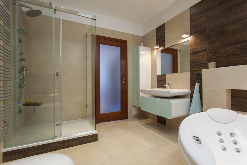 Limestone bathroom with shower area, glass door, floating vanity, and mirror