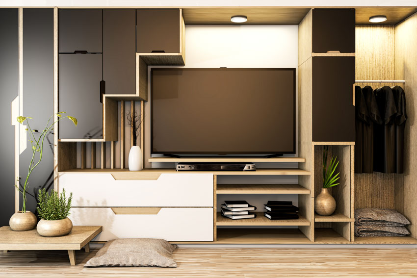 Living room with TV stand, cabinets, storage area, television, ceiling lights, and wood flooring