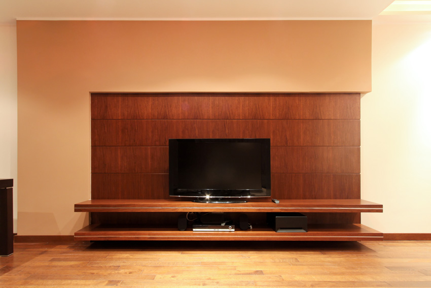 Living room with floating TV stand, LCD television, and wood flooring