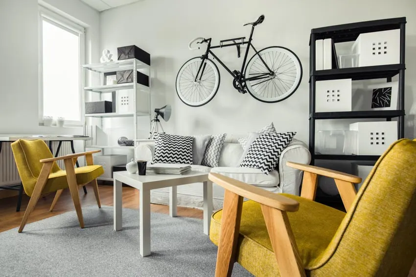 Living space with yellow couches and accent bicycle on the wall