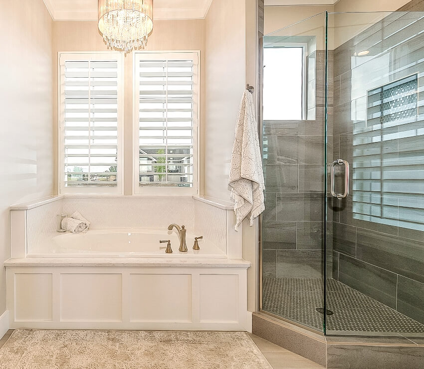 A luxurious en suite shower with penny tile flooring and bathtub