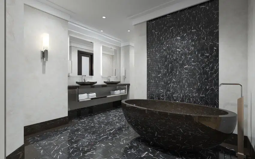 Minimalist bathroom with accent wall, black countertop, tub, flooring, mirror, and sinks