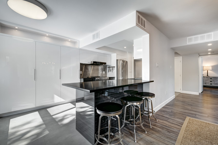 Minimalist kitchen with metal and black cushion stools