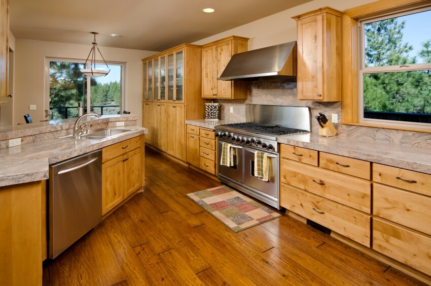 Modern kitchen with marble countertops, island, stainless appliances, and knotty wood cabinets