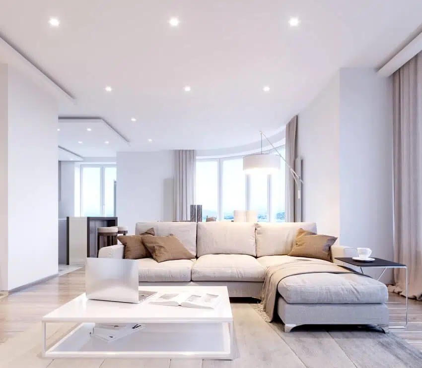 A modern white gray living room interior design with ceiling recessed lighting and big windows