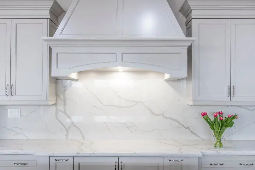 Kitchen with white marble countertop and backsplash and white cabinetry